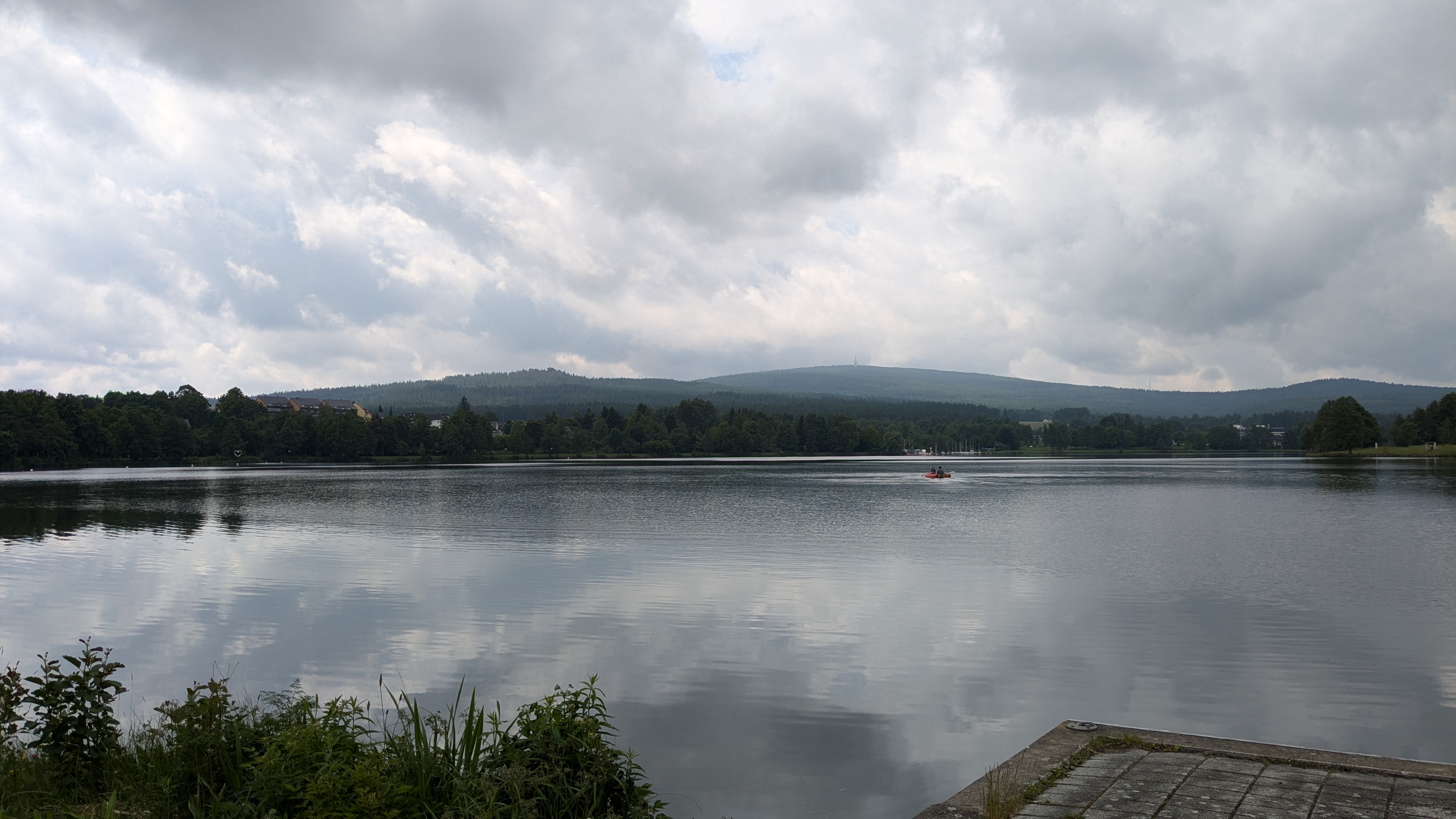 Small red rowboat carrying two scientists sampling at WeißenstädterSee